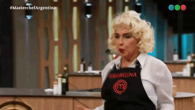 a woman wearing a black apron that says masterchef on it