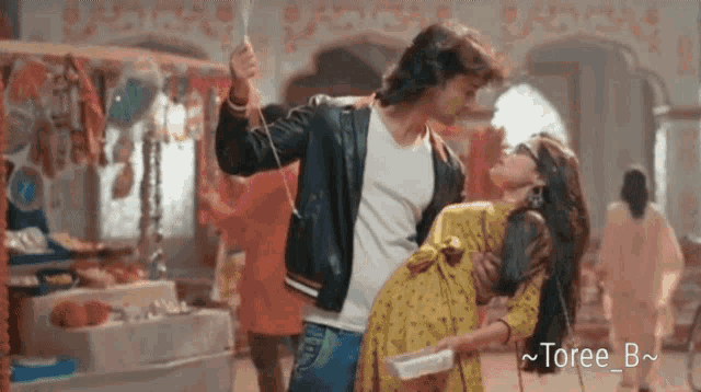 a man is holding a woman in his arms while they are dancing
