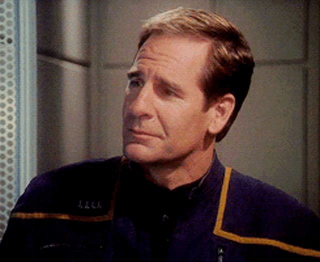 a man wearing a blue jacket with the letters a.z.a.a. on the front