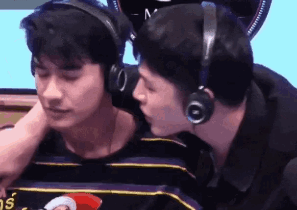 two men wearing headphones are kissing each other on the cheek .