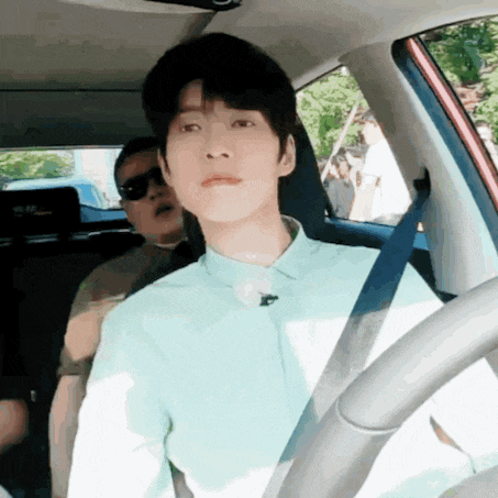 a man wearing sunglasses is sitting in the back seat of a car .