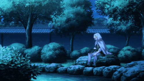 a person in a white cape sits on a rock near a pond