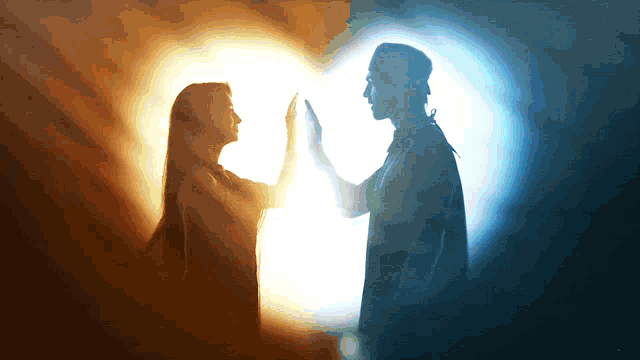 a man and a woman are touching their hands in front of a heart