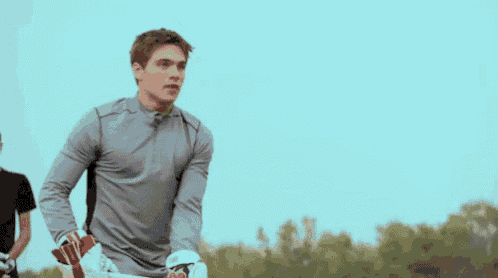 a young man is holding a lacrosse stick in his hands .