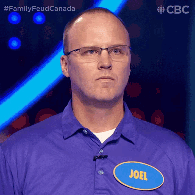 a man wearing glasses and a purple shirt has a name tag that says joel
