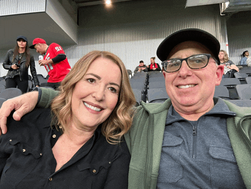 a man and a woman are posing for a picture with a man wearing a number 51 jersey