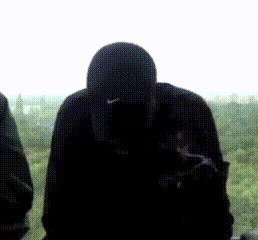 a silhouette of a man wearing a nike hat looking out a window