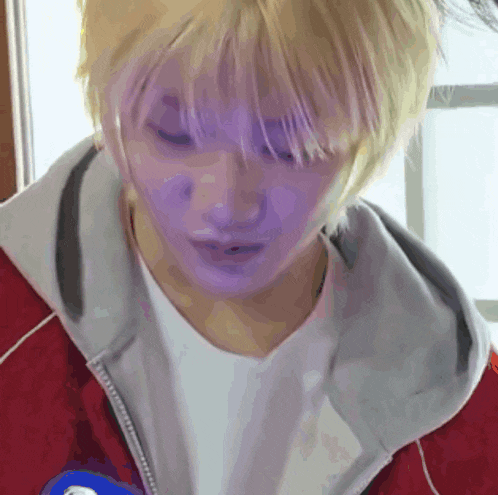 a close up of a person wearing a red jacket and white shirt