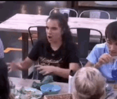 a group of people are sitting at a table in a restaurant eating food .