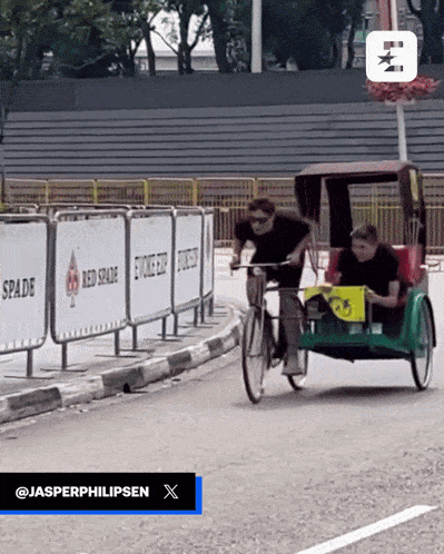 a man is riding a bicycle next to a sign that says spade on it