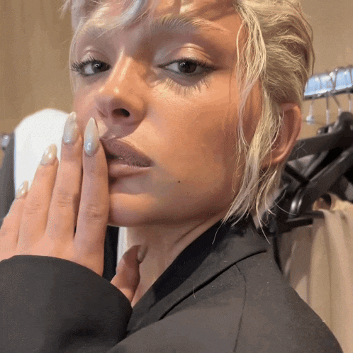 a close up of a woman 's face with her hands on her face