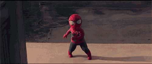 a stuffed spider-man is walking on a sidewalk in front of a building .