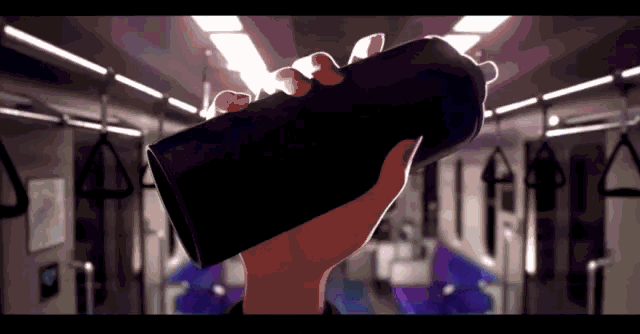 a person holding a black container in a train
