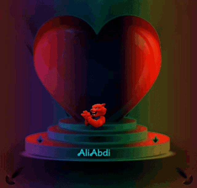 a red teddy bear is sitting in front of a large heart with the name aliabdi written on the bottom