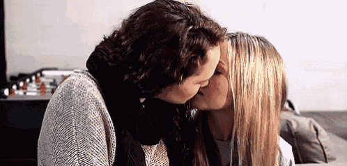 a man and a woman are kissing each other .