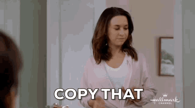 a woman is standing in front of a door with the words `` copy that '' written on the screen .