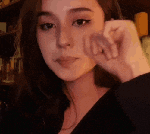 a close up of a woman 's face with her hand on her face .