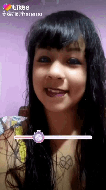 a girl with a tattoo of a heart on her chest looks at the camera