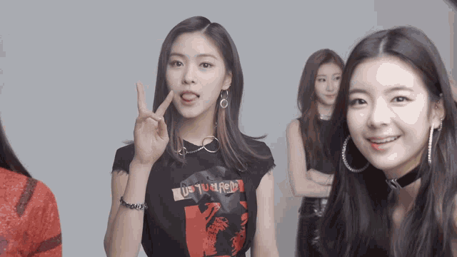 a girl wearing a shirt that says ' us ' on it sticks her tongue out