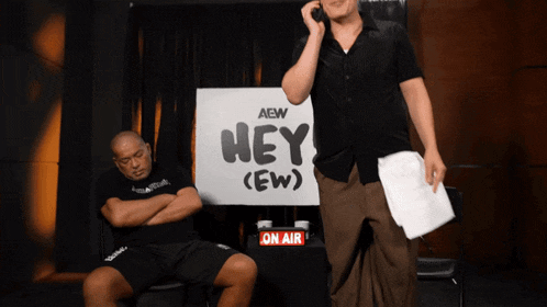 two men in front of a sign that says hey ( ew )