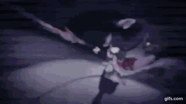 a person is holding a sword in their hand in a dark room .
