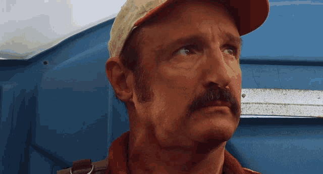 a man with a mustache wearing a hat