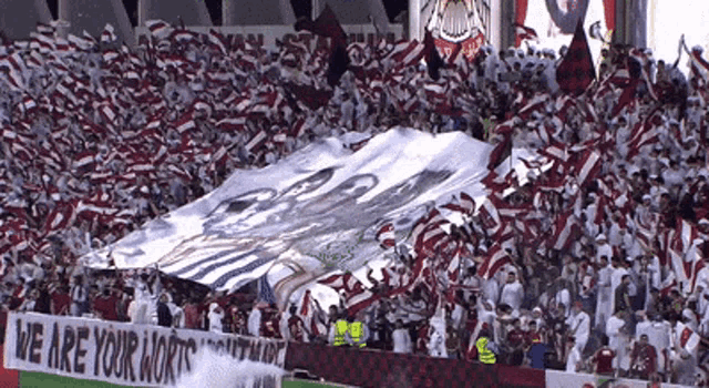 a banner that says we are your worth is in front of a crowd
