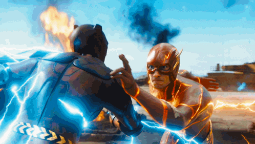 batman and the flash are fighting with lightning coming out of their bodies