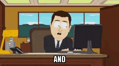 a man in a suit and tie is sitting at a desk in front of a computer and the word and is on the desk .