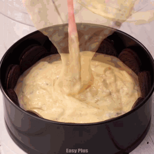 a cake batter is being poured into a pan with oreos
