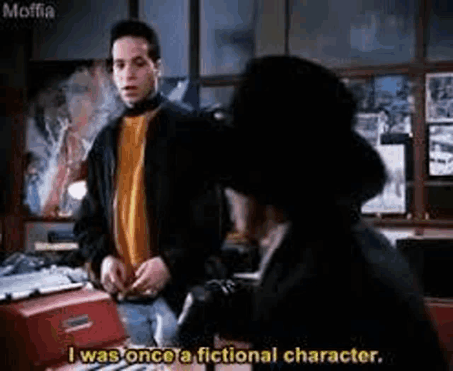 a man in a black jacket is talking to another man in a black hat in a room .