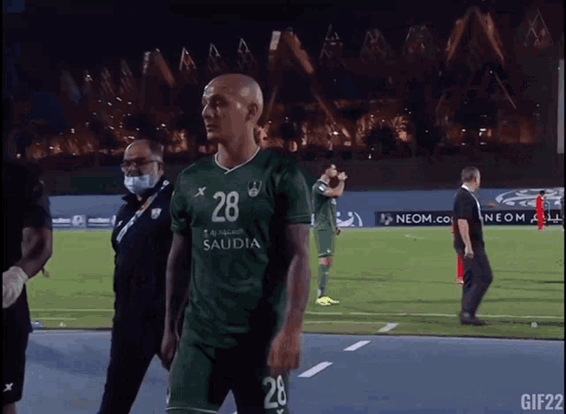a soccer player wearing a green shirt with the number 28 on it