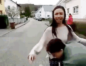 a woman is walking down a street with a man behind her and a watermark that says warddoo