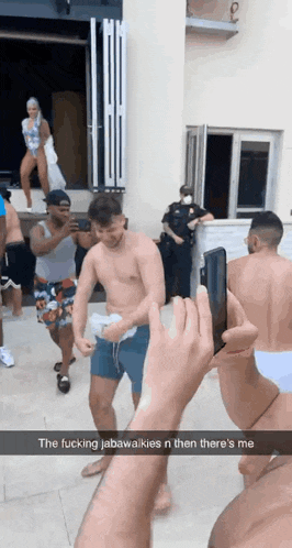 a man taking a picture of a group of people with a caption that says the fucking jabawaikies