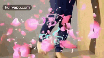 a person is standing in a room with pink petals falling on them .