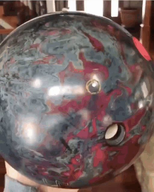 a person holding a bowling ball with a hole in the middle