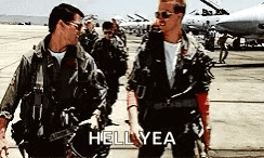 two men in military uniforms are standing next to each other on a runway and one of them says hell yea .