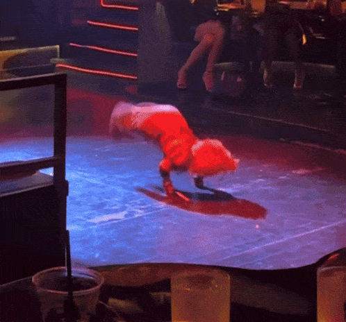 a woman is doing a handstand on a stage in a club