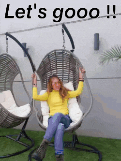 a woman in a yellow sweater is sitting in a wicker chair with the words let 's goooo !! above her .