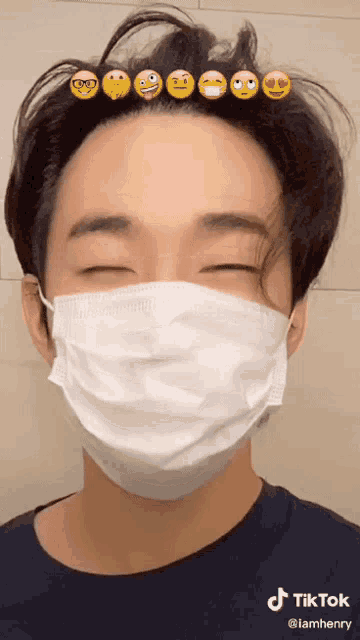 a man wearing a face mask has a bunch of emojis on his hair