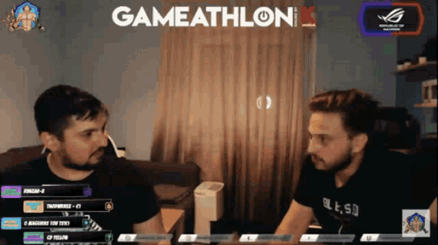 two men are sitting in front of a screen that says gameathlon k