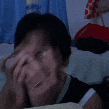 a man wearing glasses covering his mouth with his hands