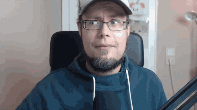 a man with glasses and a beard is wearing a hat