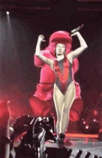 a woman in a swimsuit is dancing on a stage
