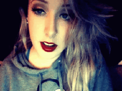 a close up of a woman 's face with red lipstick and a nose ring