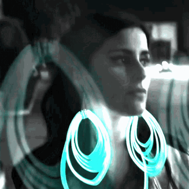 a black and white photo of a woman wearing a pair of blue hoop earrings
