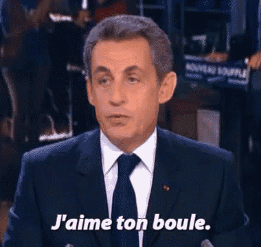 a man in a suit and tie is saying j 'aime ton boule .