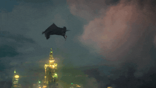 a black object is flying through the air in a cloudy sky