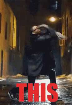 a person walking down a street at night with the word this in red
