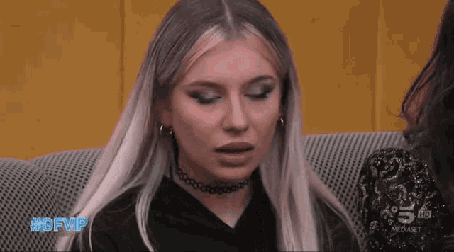 a woman sitting on a couch with the hashtag #gfvip on the bottom right